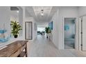 Bright hallway with white tile floors, high ceilings, and views to the living area at 5415 Limelight Dr, Apollo Beach, FL 33572