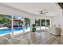 Bright living room featuring hardwood floors and sliding glass doors to the pool area at 5473 Bayshore Dr, Seminole, FL 33772