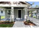 Inviting front porch with neutral tones and manicured landscaping enhances the curb appeal at 5707 N 20Th St, Tampa, FL 33610