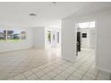 Open-concept living area featuring tile floors, an elegant front door, and seamless kitchen access at 6236 17Th S St, St Petersburg, FL 33712