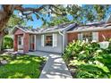 Inviting home entrance with brick accents, lush landscaping, and a pathway leading to the front door at 6561 Exeter Ct, Seminole, FL 33772