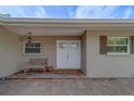 Welcoming front porch with a cozy bench, lantern, and neutral paint at 735 123Rd Ave, Treasure Island, FL 33706