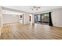 Open living room with wood-look tile flooring, sliding glass doors to the outdoors, and neutral paint at 7821 Niagara Ave # 2102, Tampa, FL 33617