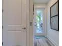 Hallway with closet, door to screened porch and stylish decor at 803 Oak Bend Ln, Dunedin, FL 34698