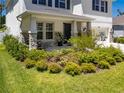 Inviting front porch with stone accents, a seating area, and lush landscaping at 8423 Praise Dr, Tampa, FL 33625