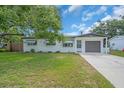 Charming single-story home with well-maintained lawn, a large shade tree, and an attached garage at 8501 56Th N St, Pinellas Park, FL 33781