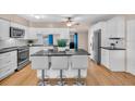 Bright kitchen with white cabinets, a large island, stainless steel appliances, and tiled backsplash at 8501 56Th N St, Pinellas Park, FL 33781