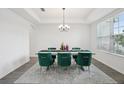 The dining room showcases a modern chandelier, contemporary decor, and stylish, comfortable green chairs at 9508 Pyrenees Pl, Seffner, FL 33584