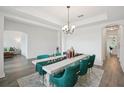 Formal dining room featuring a decorative table runner, comfortable green chairs and modern decor at 9508 Pyrenees Pl, Seffner, FL 33584
