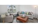Bright living room with a large window, comfortable seating, and modern accents at 9508 Pyrenees Pl, Seffner, FL 33584