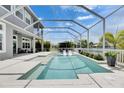 A luxurious screened-in pool area features a sparkling pool, spa, and comfortable seating, perfect for relaxation at 978 Signet Dr, Apollo Beach, FL 33572