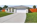 A concrete driveway leads to a two-car garage, complemented by a green lawn at 10115 Briar Cir, Hudson, FL 34667