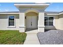 Welcoming front entrance featuring an arched doorway and modern lighting fixtures at 10115 Briar Cir, Hudson, FL 34667