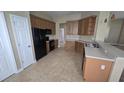 Functional kitchen equipped with stainless steel appliances, wooden cabinetry, and tile flooring at 11341 Durham St, Parrish, FL 34219
