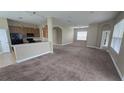 Open-concept living space featuring neutral paint, carpeted floors, and arched entryways to the kitchen at 11341 Durham St, Parrish, FL 34219