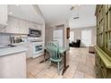 Bright eat-in kitchen with stainless steel appliances, white cabinetry, and a casual dining area at 12400 Park Blvd # 417, Seminole, FL 33772