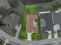 Overhead shot of the property, revealing the well-maintained lawn, enclosed patio, and surrounding landscape, showcasing the property lines at 12413 Woodlands Cir, Dade City, FL 33525