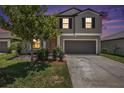 Charming two-story home featuring a well-maintained lawn and an attached two-car garage at 1655 Blue Rose Dr, Ruskin, FL 33570