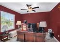 Cozy office space with dark red walls and a large window with natural light at 1655 Blue Rose Dr, Ruskin, FL 33570