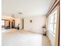 Bright living room with large windows, plush carpeting, ceiling fan, and classic chandelier at 1808 Elmwood Dr, Oldsmar, FL 34677
