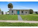 Charming single-story home with a blue front door and a well-manicured lawn at 21536 Holdern Ave, Port Charlotte, FL 33952