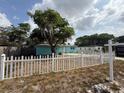View of the front yard with a white picket fence and a Century 21 real estate sign at 2175 20Th Sw Ave, Largo, FL 33774