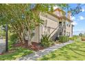 Inviting exterior of a two-story condo building with lush landscaping and a stairway entrance at 2400 Feather Sound Dr # 528, Clearwater, FL 33762