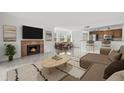 Bright living room featuring a fireplace, an open floor plan, and a modern kitchen with stainless steel appliances at 2400 Feather Sound Dr # 528, Clearwater, FL 33762