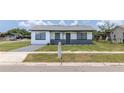Charming single-story house with a well-kept lawn and long driveway at 2425 Wishing Well Cir, Tampa, FL 33619