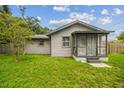 Cozy single-story house featuring a screened-in porch, a well-maintained lawn, and classic architectural details at 2607 N 59Th St, Tampa, FL 33619