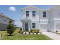 Attractive townhome featuring light blue accents, a one-car garage, and a tidy front lawn at 3062 Victoria Inlet Dr, Holiday, FL 34691