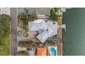 Aerial view of a waterfront home featuring a screened-in pool, boat dock, and well manicured yard at 3830 46Th S Ave, St Petersburg, FL 33711