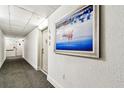Hallway with carpet and textured walls leading to unit 502, decorated with a painting at 400 Island Way # 502, Clearwater Beach, FL 33767