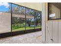 Relaxing screened porch with views of lush trees and a serene lake, perfect for enjoying the outdoors in comfort at 440 Lakeview Dr # 34, Palm Harbor, FL 34683