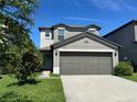 Well-maintained two-story home with a driveway, attached garage, manicured lawn, and trimmed bushes at 4448 Globe Thistle, Tampa, FL 33619