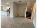 Open-concept living space with tile flooring and staircase, seamlessly connecting to the modern kitchen at 4448 Globe Thistle, Tampa, FL 33619
