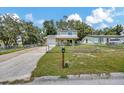 A charming two-story home featuring a fenced-in yard, a driveway, and mature trees at 4612 E Seneca Ave, Tampa, FL 33617