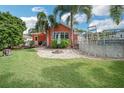 Spacious backyard featuring a pool, lush lawn, and inviting fire pit area at 51 Cypress Dr, Palm Harbor, FL 34684