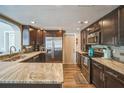 Modern kitchen featuring stainless steel appliances, granite countertops, and dark wood cabinetry at 51 Cypress Dr, Palm Harbor, FL 34684