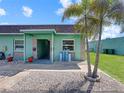 Charming exterior of home with lush landscaping, green walls, and nice decorations on a beautiful, sunny day at 599 Westwinds Dr # 9, Palm Harbor, FL 34683