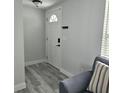 Bright entryway features wood-look flooring and a modern front door with ample natural light at 6008 Firefly Ln, Apollo Beach, FL 33572