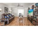 Comfortable living room with wood flooring, a ceiling fan, and a leather sofa at 630 Mac Crillus Rd, Largo, FL 33770