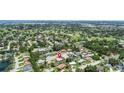 An aerial view showcases the property's location within a lush, green neighborhood near a golf course at 6921 8Th Street E Ct, Sarasota, FL 34243