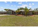 Single-story home with well-kept lawn and tropical landscaping, complemented by a two-car garage at 6921 8Th Street E Ct, Sarasota, FL 34243