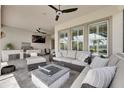 Inviting covered patio with stylish seating, a fire pit, an outdoor grill, and ceiling fans at 7420 Paradiso Dr, Apollo Beach, FL 33572