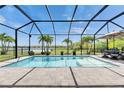 Relaxing screened-in pool with a beautiful water view, patio furniture, and lovely landscaping at 7420 Paradiso Dr, Apollo Beach, FL 33572