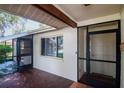 Enclosed porch area with screens and access to the front entrance and an interior door at 8626 Woodbridge Dr, New Port Richey, FL 34655