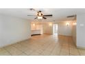 Spacious living room featuring tile floors, neutral paint, and a ceiling fan at 8804 Lido Ln, Port Richey, FL 34668