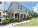 Low angle of charming two-story exterior featuring front yard landscaping and a brick-paved walkway at 106 Cutlass Way, Oldsmar, FL 34677