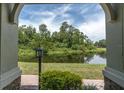 Scenic view of a tranquil pond framed by an arched doorway with lush greenery and a serene atmosphere at 106 Cutlass Way, Oldsmar, FL 34677